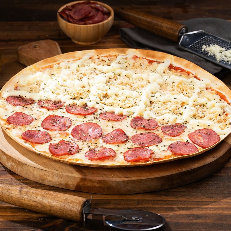 Delicie-se com a nossa Pizza Grande de 35cm, uma joia culinária que oferece a oportunidade de combinar até dois sabores distintos. Aprecie a combinação perfeita de ingredientes frescos e de qualidade superior, cuidadosamente selecionados para proporcionar um sabor divino. Os sabores, unidos em harmonia sob a crosta crocante e dourada, criam uma experiência gustativa inigualável. Seja para uma noite de conforto em casa ou para uma reunião com amigos, esta pizza é a escolha perfeita para ocasiões especiais ou simplesmente para uma refeição deliciosa e satisfatória.