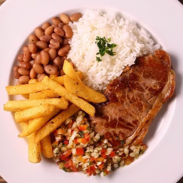 Delicioso bife de contra filé grelhado acompanha arroz feijão farofa e vinagrete