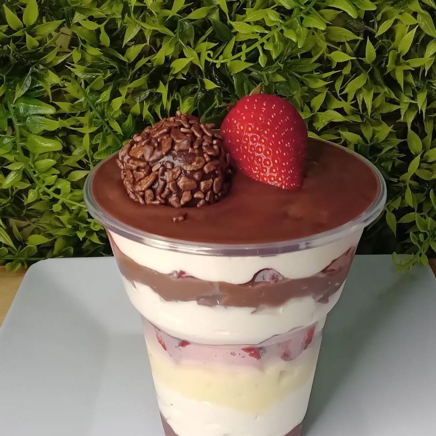 Mousse de leite Ninho, recheio de chocolate branco, recheio de chocolate cremoso, morangos picados e finalizado com brigadeiro e morango.