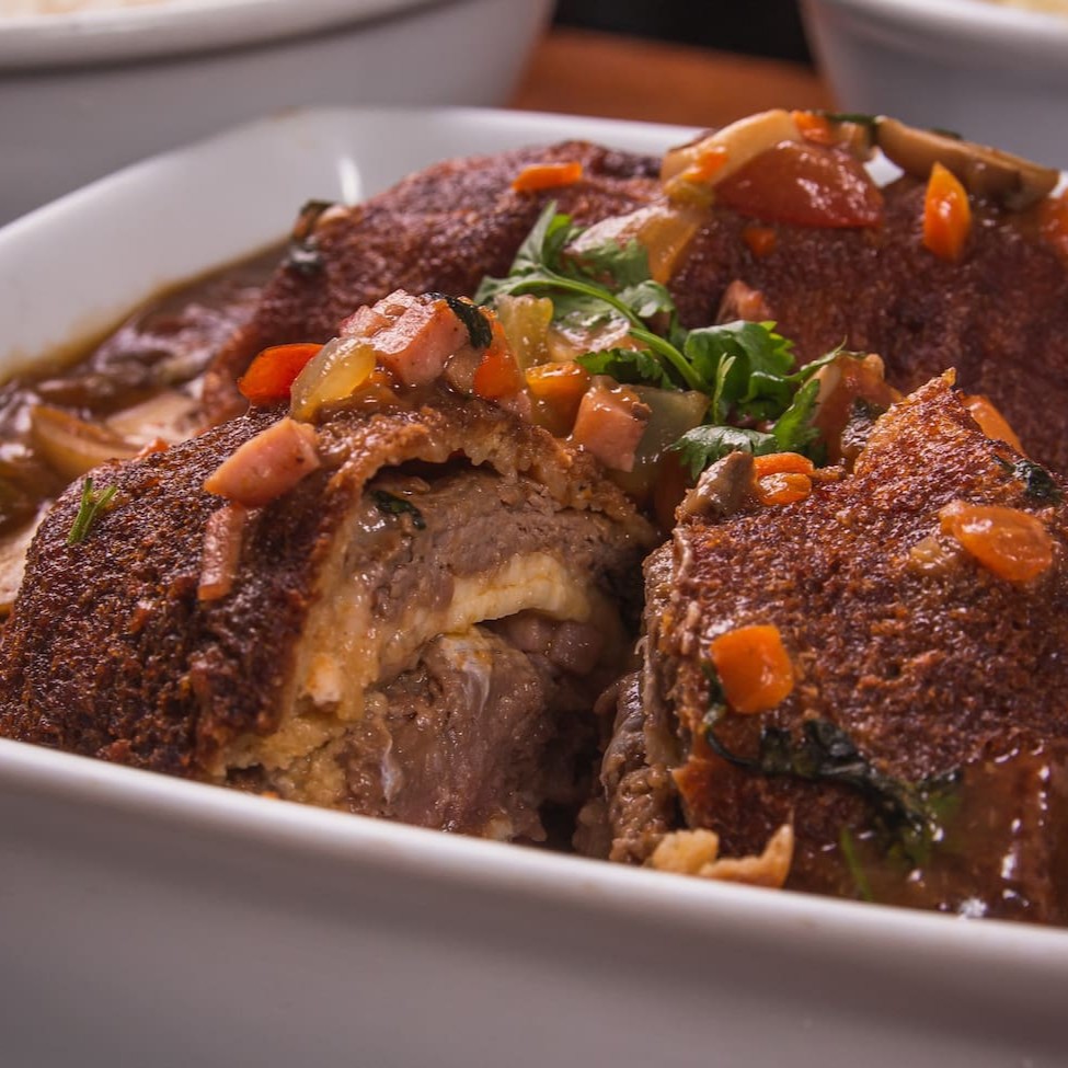 - filet mignon recheado c/ presunto, muçarela, envolvido ao molho madeira, tomate, cebola e ervilha, Acompanhamento: Arroz à grega e macaxeira frita