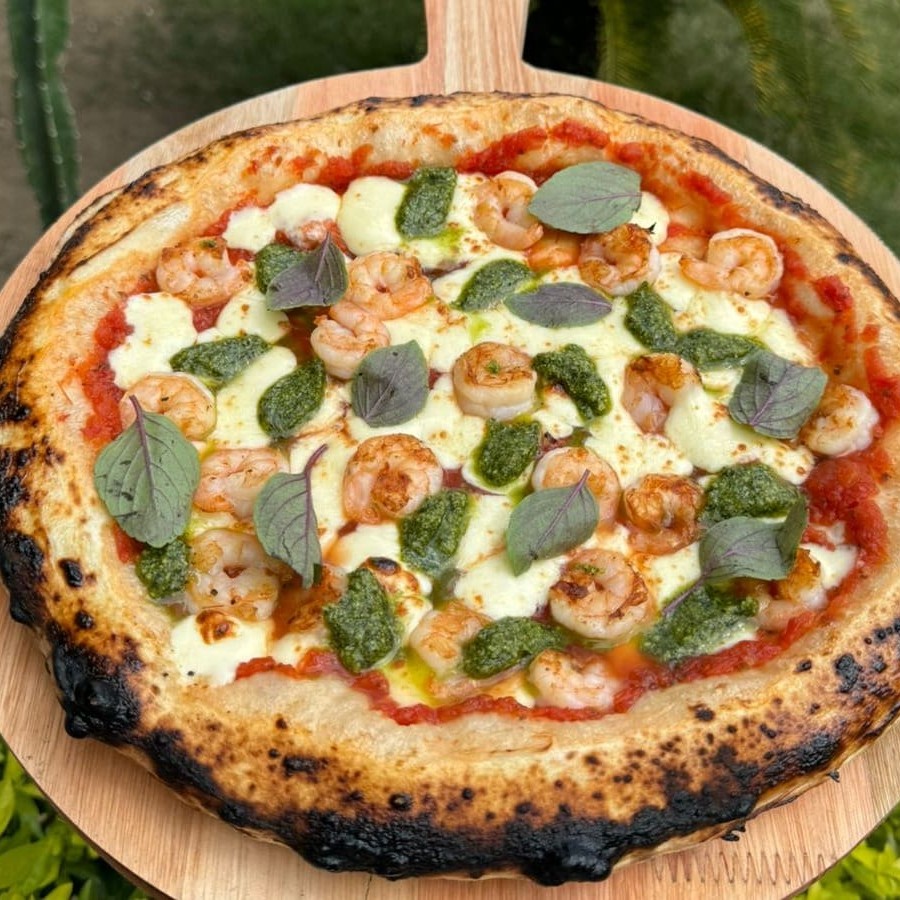 Molho de tomate, muçarela, camarões frescos e limpos e molho pesto.