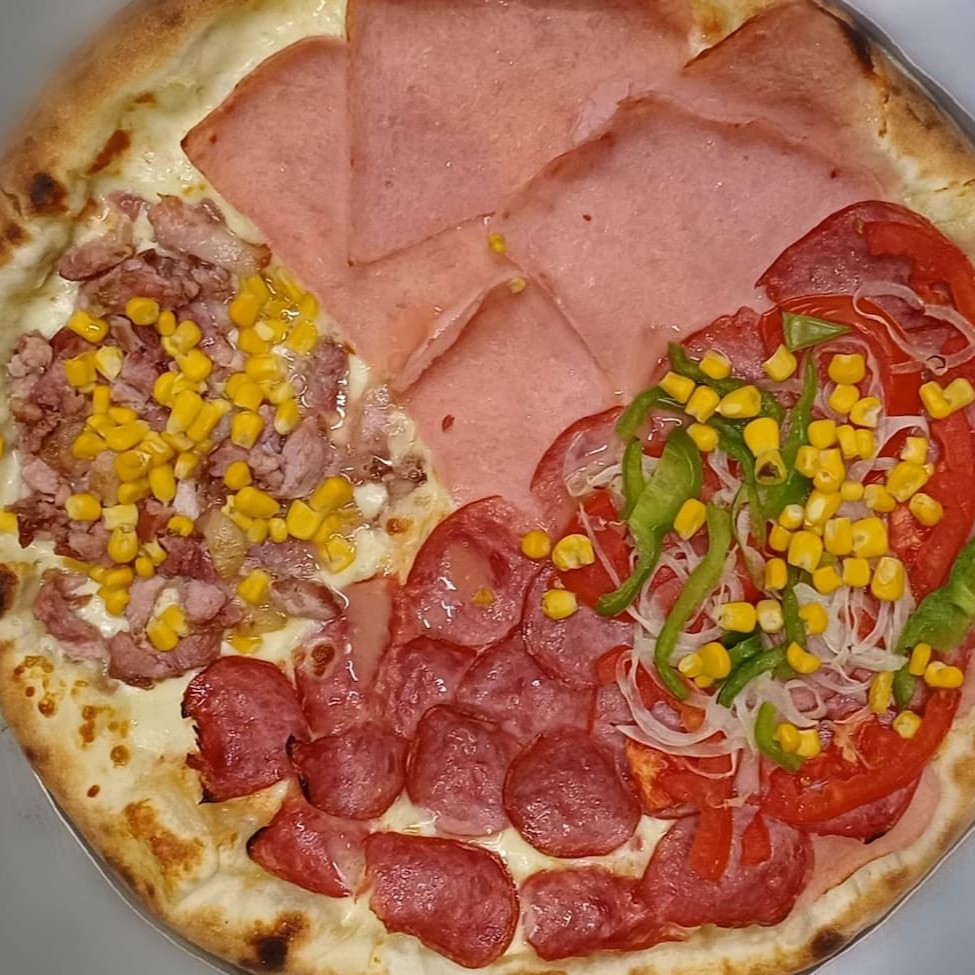 Nossa deliciosa pizza de 4 sabores: calabresa, presunto, brooklyn e bacon com milho no tamanho Gg com 8 fatias. Sendo duas fatias de cada sabor.