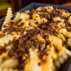 Batata frita com molho cheddar e bacon e calabresa