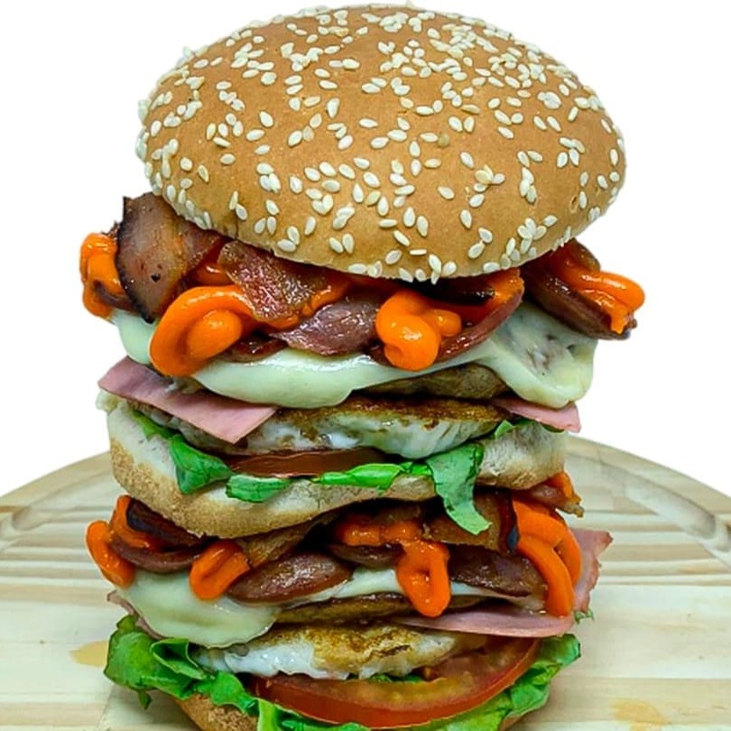 Apresentando o 'Ufc', o maior e mais irresistível hambúrguer do nosso cardápio. Este majestoso hambúrguer é cuidadosamente montado com ingredientes de alta qualidade, todos em dose dupla para a sua satisfação. Entre o pão macio, encontram-se camadas generosas de deliciosa maionese, alface crocante, tomate fresco, ovo perfeitamente frito, presunto suculento, uma robusta carne de hambúrguer, queijo mussarela derretido, calabresa picante, bacon crocante e o cremoso cheddar. É um verdadeiro banquete em forma de hambúrguer. Garantimos que este produto chegará quentinho e irresistível à sua residência, proporcionando uma experiência gastronômica inigualável. Experimente o melhor hambúrguer do !