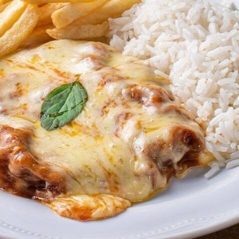 Empanado crocante, molho caseiro e queijo gratinado, servidos com acompanhamentos que completam a experiência. Escolha entre fritas, aipim ou salada