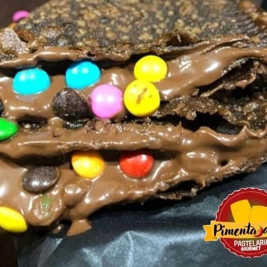 Pastel de aproximadamente 15cm com recheio de chocolate ao leite com confetes coloridos de chocolate.