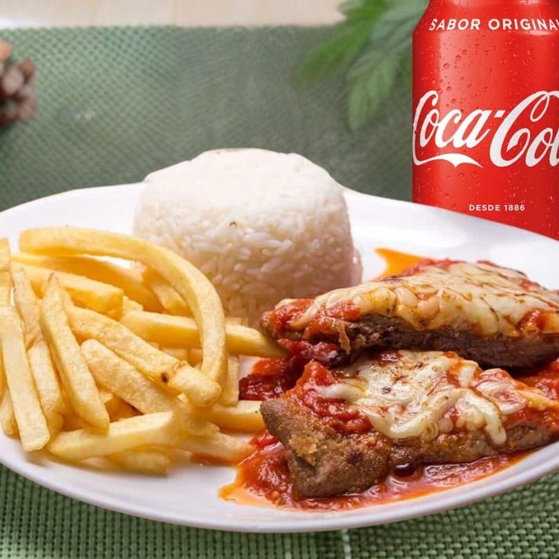 Suculento bife a parmeggiana acompanhado de arroz soltinho, feijão muito bem temperado, farofa, salada e fritas + uma Coca - Cola Lata 350ml Bem gelada. Marmita 800grs