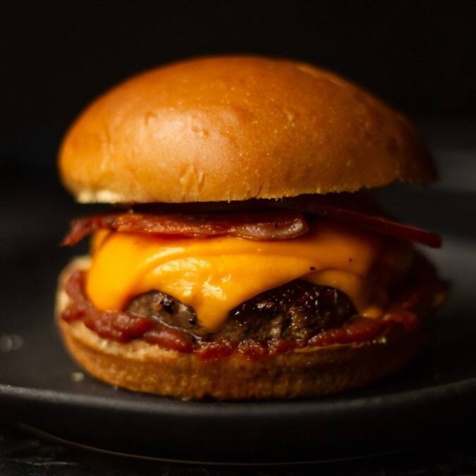 Apresentamos o 'Yakuza Picanha 1', uma obra-prima culinária da categoria 'Yakuza Burguers'. Este lanche é montado em um pão de brioche fresco e macio, generosamente coberto com uma maionese de bacon caseira, irresistivelmente saborosa. No coração do burger, temos uma suculenta carne de picanha de 120g, cuidadosamente selecionada e grelhada à perfeição. Para acentuar ainda mais o paladar, adicionamos uma camada de queijo cheddar derretido, trazendo uma cremosidade inigualável ao prato. E como se não bastasse, o bacon crocante adiciona uma textura deliciosa. Acompanha uma porção de batatas de 120g, perfeitamente fritas e temperadas. Uma verdadeira explosão de sabor!