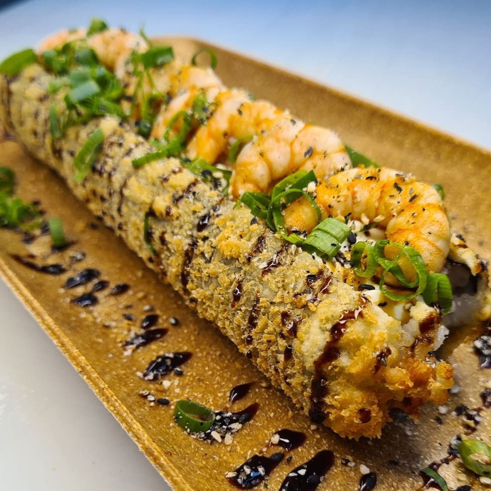 Enrolado de arroz empanado, cream cheese, salmão, camarão, cebolinha, teriaki e gergelim