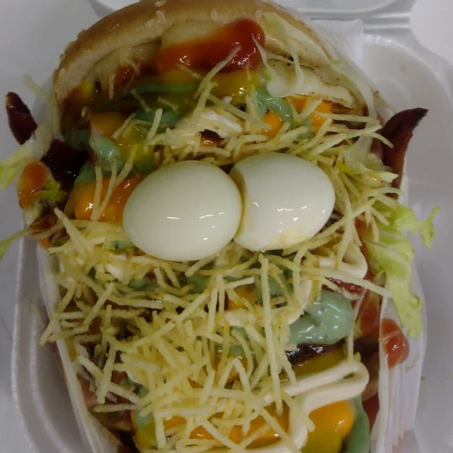 Nosso irresistível X-Tudo Trembão com pão fresquinho, suculenta carne, queijo derretido, presunto defumado, bacon crocante e saborosa calabresa. Para uma textura extra, adicionamos batata palha crocante, milho e um delicioso molho cheddar e Catupiry uma porção de alface fresca e tomate suculento. Satisfaça o seu desejo de um Trembão completo e delicioso!