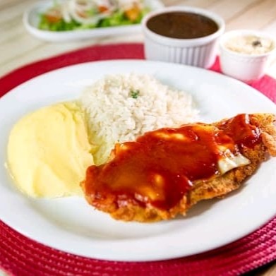 Desfrute de um prato que combina a tradição italiana com o sabor brasileiro, com filé de frango à parmegiana empanado e coberto com queijo derretido e molho de tomate caseiro. Acompanha arroz soltinho, feijão saboroso, farofa com calabresa (em embalagem separada) e mais um acompanhamento à sua escolha.  Nossas refeições são servidas em embalagem de isopor de aproximadamente 700ml.