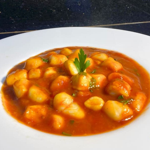 A tradição italiana em sua forma mais simples e saborosa! Perfeito para quem ama um prato reconfortante.  Nhoque artesanal de batata, leve e macio, mergulhado em um molho sugo rústico, feito com tomates frescos, manjericão e alho. Um molho de sabor intenso e envolvente, que traz um toque caseiro e acolhedor. Finalizado com uma generosa camada de queijo parmesão ralado na hora. Embalagem especial.