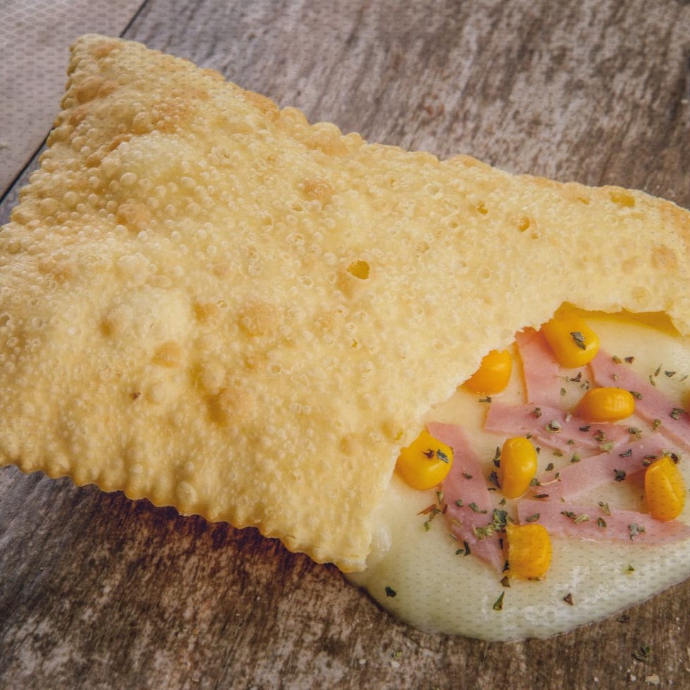 Pastel delicioso de massa crocante recheado com presunto, queijo muçarela, requeijão cremoso, milho e orégano