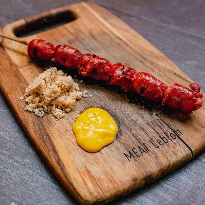 1 unidade de espeto de linguiça acompanhado de farofa de bacon e molho barbecue.