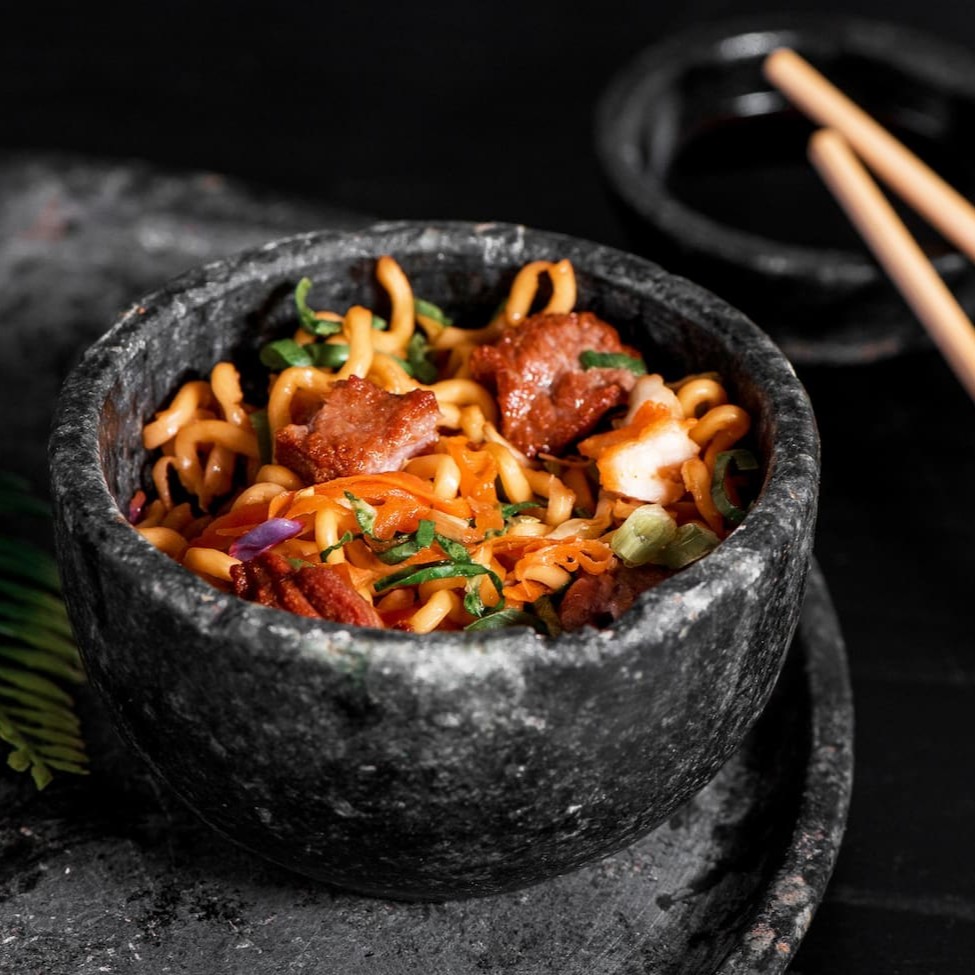 Macarrão oriental refogado com carne, cenoura, acelga, couve, repolho roxo e repolho verde, finalizado com shoyu, óleo de gergelim e cebolinha