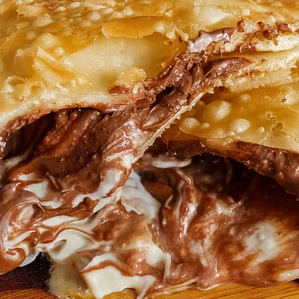 Chocolate branco com chocolate preto.  Pastel com aproximadamente 19cm.