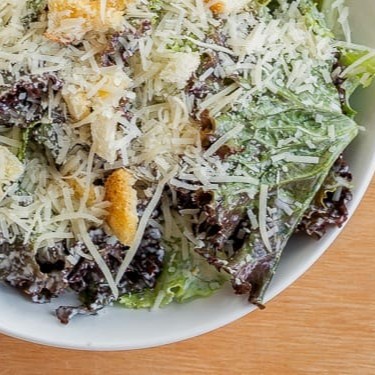 Clássica Salada Caesar com croutons caseiros, queijo parmesão fresco ralado e o nosso delicioso molho aioli.