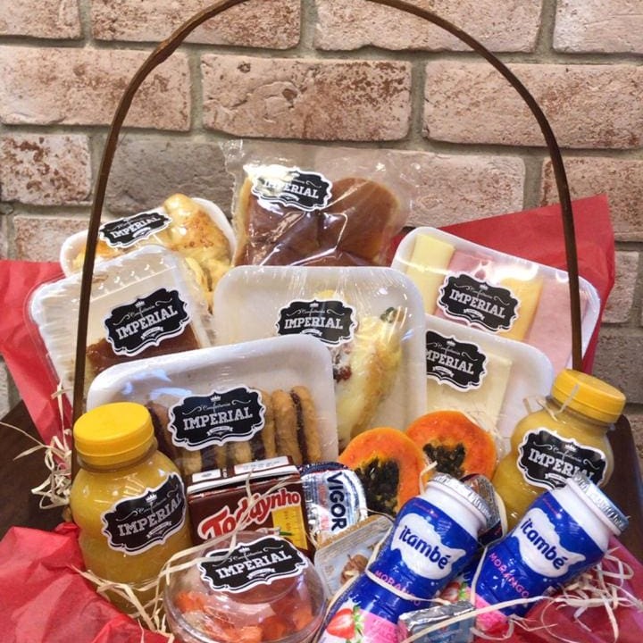 Cesta Contendo:  02 Saladas de frutas 02 sucos laranja 300ml 01 Pão doce  02 Iogurtes integrais com granola  01 pct de pão brioche (09 un)   1 bolo Imperial 01 porção de queijo minas (100g) 01 porção de peito de peru (100g) 1 toddynho 8 pães de queijo 01 Porção de biscoito amanteigados (100g)               02 porções de geleia  02 manteigas pq 01 porção de mamão papaya 01 pacote de financier  Todas nossas opções de cestas são disponibilizadas com papel seda e celofone   Obs: no caso de indisponibilidade de algum item, este será substituído por outro de valor equivalente ao em falta.  imagem ilustrativa.