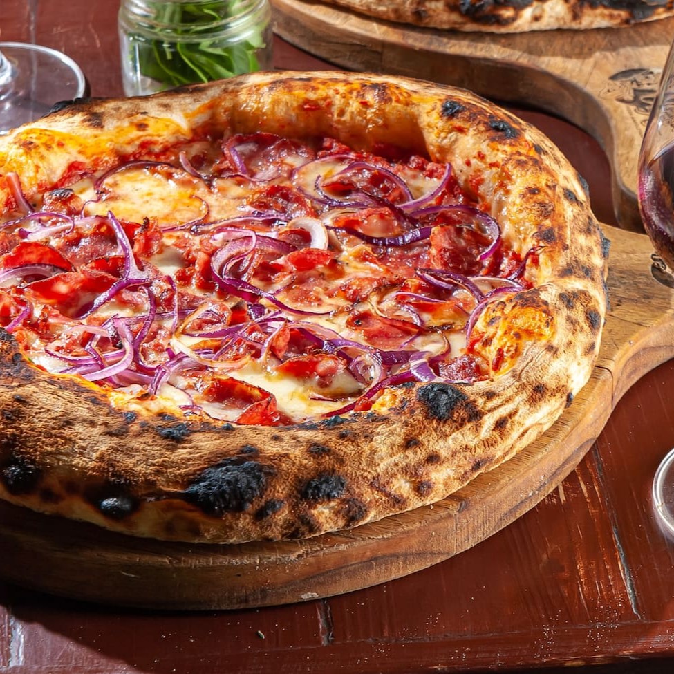 Massa em fermentação natural, molho de tomate, calabresa defumada, mozzarela e cebola roxa