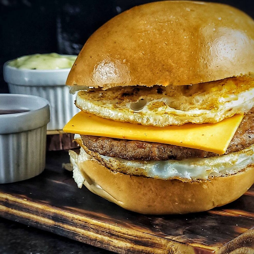 Apresentamos o nosso X-Egg, um requintado representante da categoria ' Sanduíches Americanos'. Este saboroso prato começa com um macio pão bola, que abriga uma generosa porção de suculenta carne. Acrescentamos uma camada de queijo cheddar derretido. Não paramos por aí! Adicionamos dois ovos Fritos à perfeição, harmonizados com o nosso exclusivo e irresistível molho especial da casa. Um toque de ketchup. Um sanduíche sublime que vai além do comum, ideal para satisfazer os paladares mais exigentes.