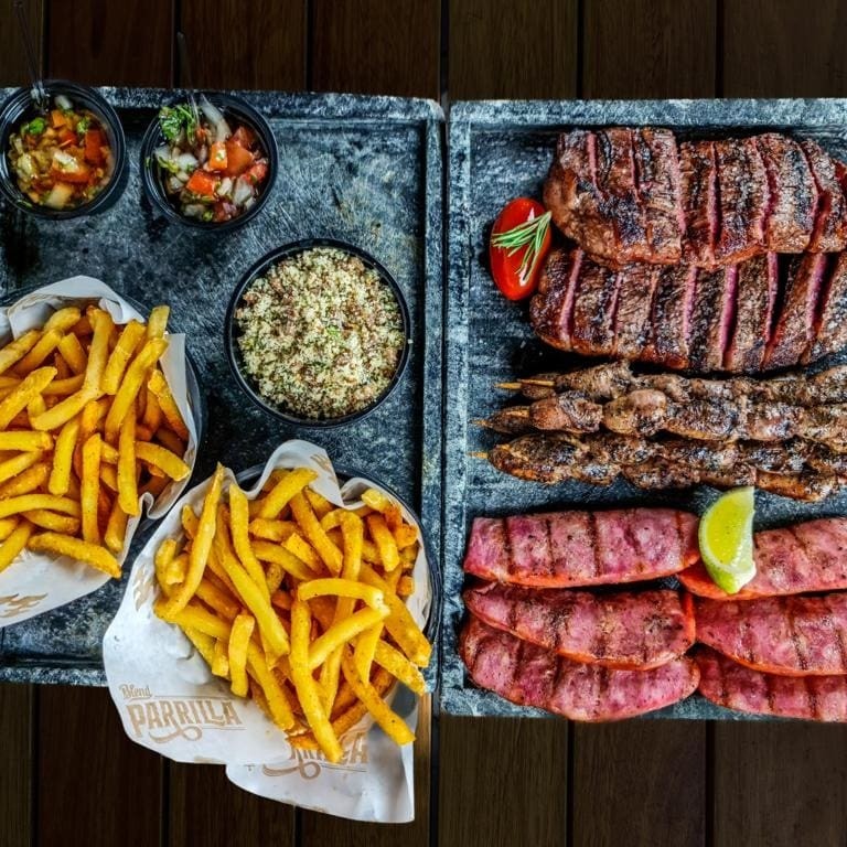 São 440g de picanha! Picanha premium, linguiça de pernil, coração assado na brasa, molho chimichurri artesanal, farofinha de alho, batata frita e molho à campanha.