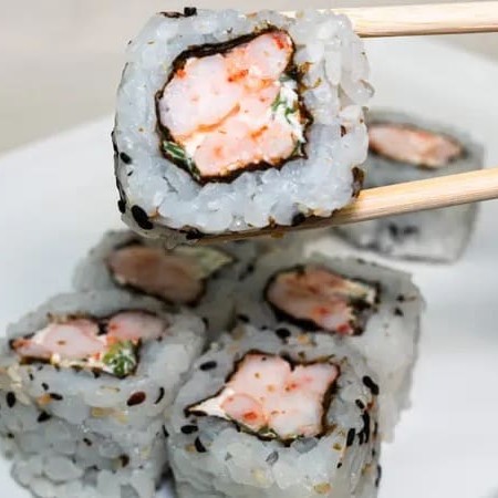 Camarão e cream cheese enrolado com alga, arroz japonês por fora e gergelim.