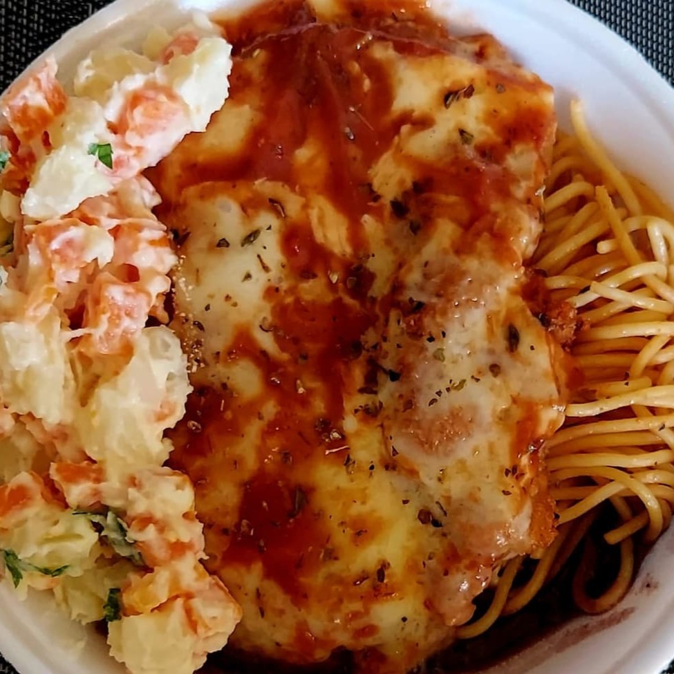Delicioso filé de frango à parmegiana, preparado com carinho e dedicação, coberto com queijo derretido e suculento molho de tomate. Acompanha um trio clássico e indispensável: feijão fresquinho, arroz soltinho e um macarrão ao molho. Para completar, uma farofa crocante que traz um toque especial ao prato. Todas as refeições incluem um refrescante Guaracrac. Escolha o acompanhamento para personalizar ainda mais sua experiência gastronômica. Uma opção de almoço que combina sabor e tradição em cada garfada!