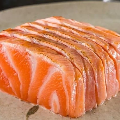 Laminas de salmão fresco finalizadas com um toque refinado de azeite trufado e flor de sal, levemente maçaricado. Uma explosão de sabor que equilibra a untuosidade do peixe com a sofisticação do trufado e o realce delicado da flor de sal.