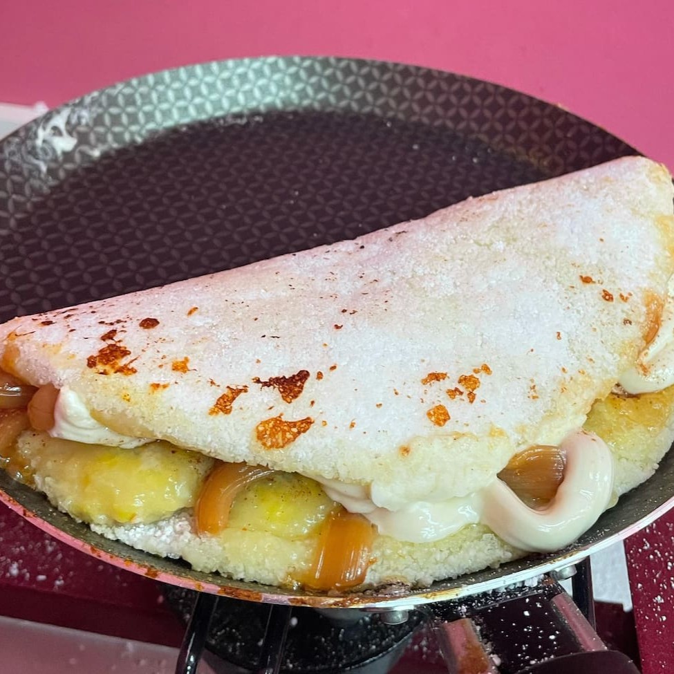 Uma Explosão De Sabores Que Derrete Na Boca!   Se liga nessa combinação dos sonhos: banana docinha, queijo mussarela derretido, doce de leite cremoso e chocolate branco caramelizado com maçarico, finalizado com uma pitada de canela.   Cada mordida é uma viagem ao paraíso dos sabores!  Peça agora e se permita essa experiência