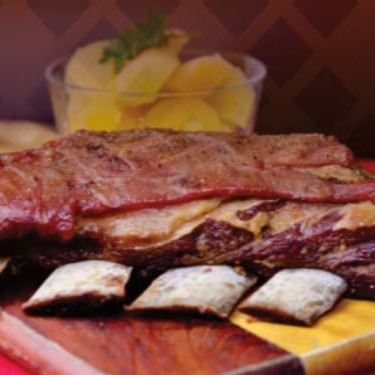 Costela bovina marinada em tempero especial por doze horas e assada no bafo por seis horas. Servidas com batatas cozida e cebolas. Acompanha farofa da casa e molho a campanha.