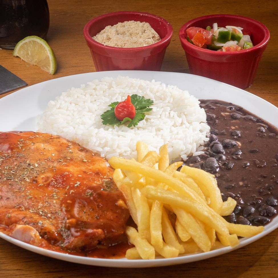 Apresentamos a inconfundível 'Parmegiana de Carne' da categoria 'Novidade Parmegiana!'. Esta delícia é composta por um sofisticado bife de carne bovina, criteriosamente selecionado, revestido com queijo prazerosamente derretido e um molho de tomate artesanal, transbordando sabor. Acompanha, generosamente, arroz aromaticamente perfeito e batatas fritas de crocância invejável e douração ideal. Uma combinação que garante uma experiência gastronômica memorável!