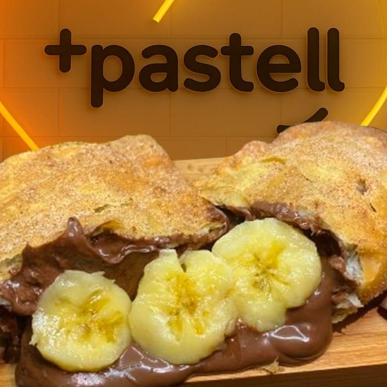 Delicie-se com o irresistível Bananutella! Uma massa de pastel de 15cm, sequinha e crocante, recheada generosamente com banana d'água e Nutella Original. Após ser frito, é delicadamente polvilhado com uma mistura irresistível de canela e açúcar. Surpreenda seu paladar com essa combinação perfeita de sabores e texturas!