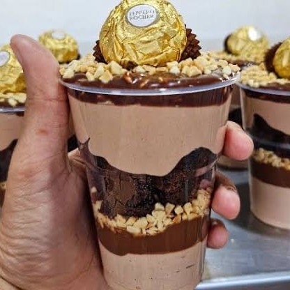 Uma generosa camada de brigadeiro de ferreiro,uma camada de amendoim torrado uma camada,de brownie, uma camada de chantilly Ninho de chocolate com o nosso maravilhoso brigadeiro 50%cacau finalizado com bombom ferreiro Rocher