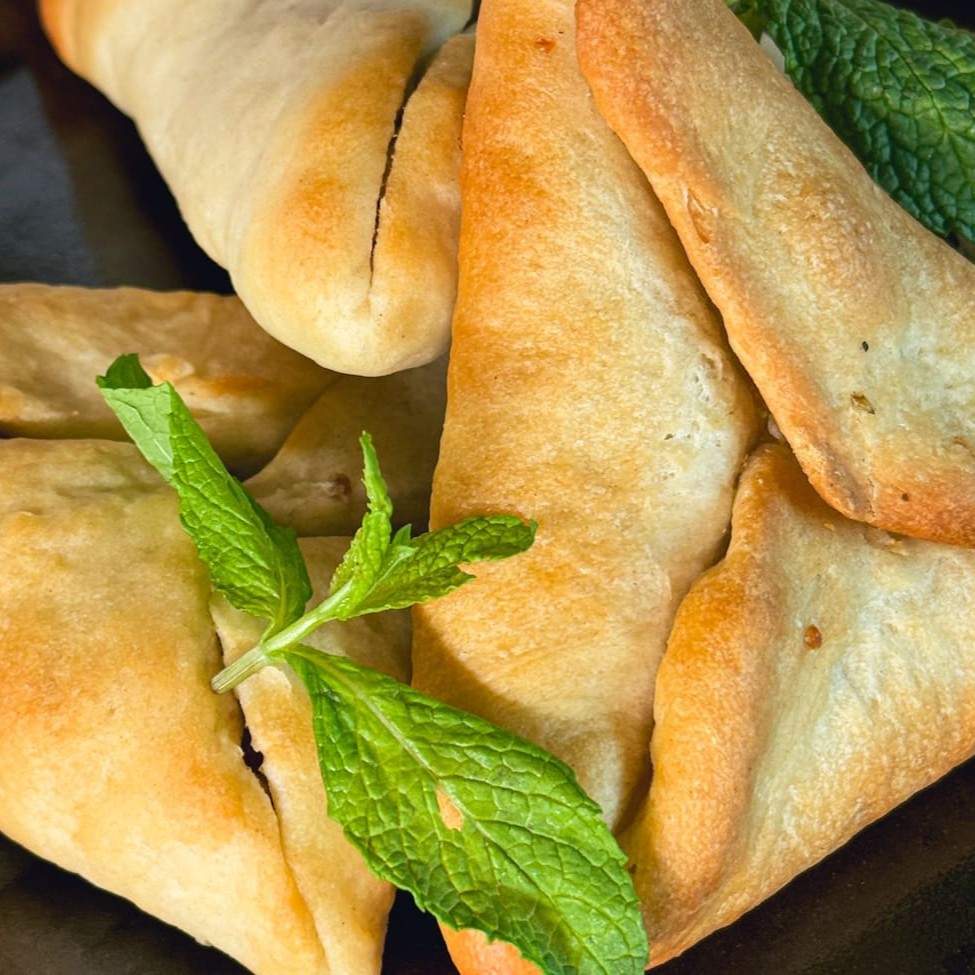 Esfiha de Queijo Fechada com massa fofinha e dourada que envolve um recheio cremoso e irresistível, feito com uma combinação especial de queijos selecionados, derretidos na medida certa para proporcionar uma explosão de sabor a cada mordida. Perfeita para quem ama o equilíbrio entre simplicidade e sofisticação.