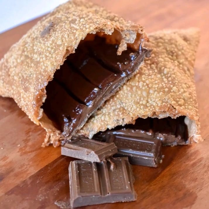 Um pastel Hershey's é uma deliciosa iguaria composta por uma massa leve e crocante, recheada com generosos pedaços de chocolate Hershey's derretido, que se funde em uma experiência indulgente e reconfortante para os amantes de chocolate. Cada mordida oferece uma explosão de sabor de cacau, complementada pela textura macia da massa, criando uma combinação irresistível que faz os corações dos chocólatras vibrarem de felicidade.