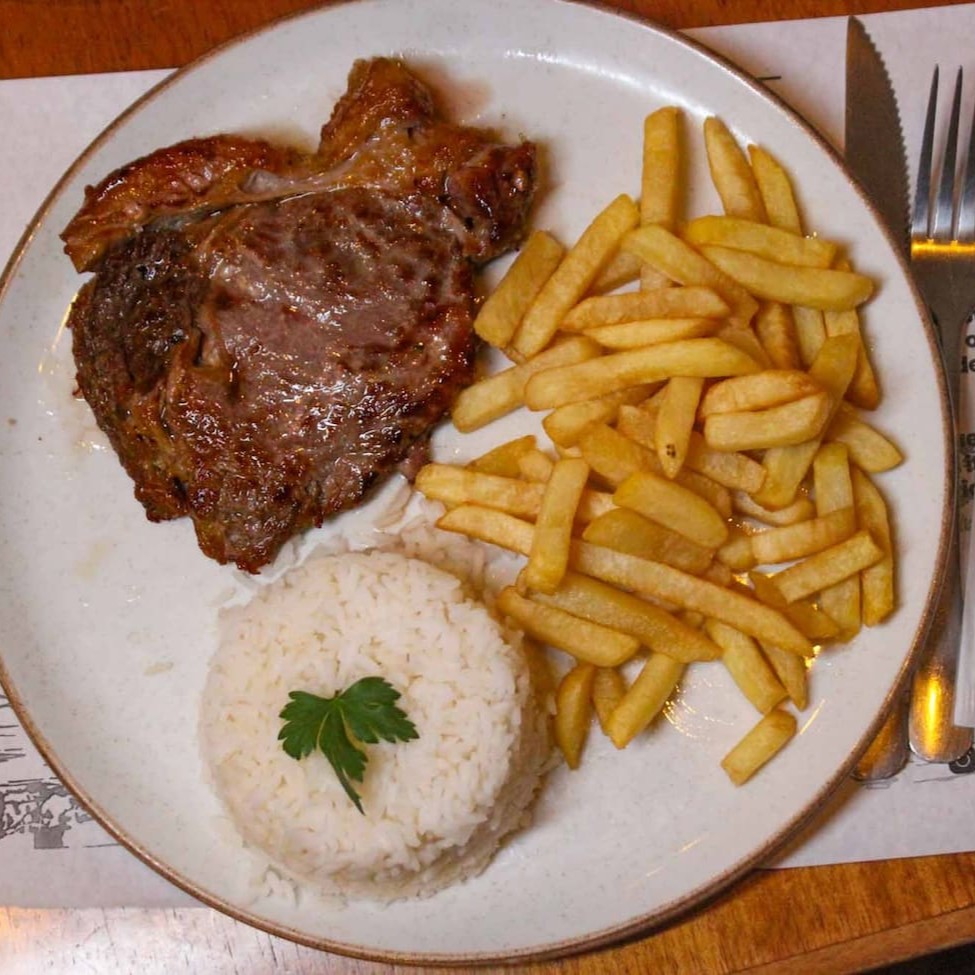 Corte suculento de contra filé grelhado no ponto ideal, acompanhado de batata frita crocante, arroz branco soltinho e feijão cremoso. Uma refeição completa, saborosa e cheia de energia para o seu Dia!