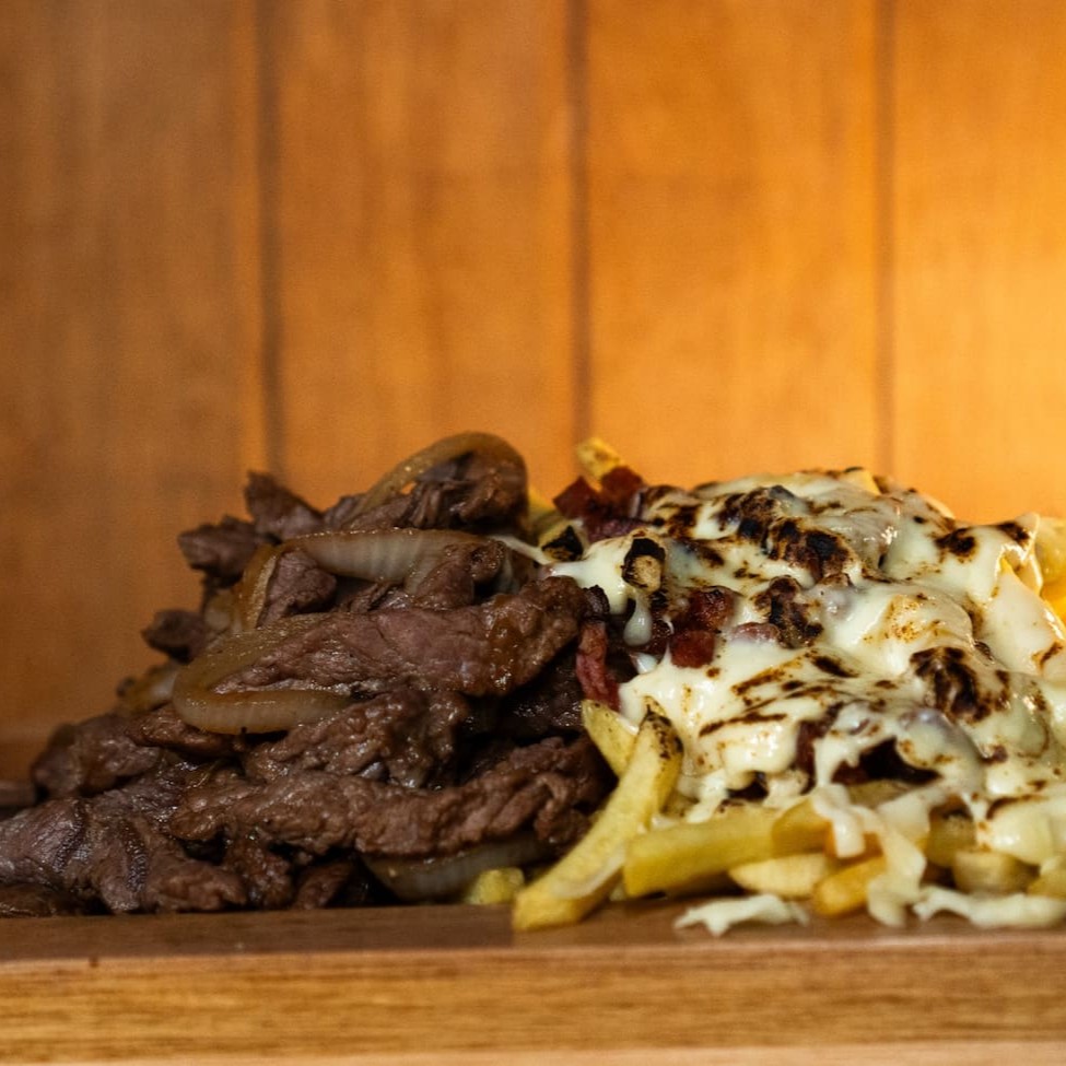 Apresentamos o nosso inconfundível 'Filé de Carne com Fritas Simples', uma das estrelas da nossa seção 'Porções'. Este prato é composto por generosos 500 gramas de um suculento coração de alcatra, cuidadosamente selecionado e impecavelmente acebolado, proporcionando um sabor inigualável. Acompanha ainda, 500 gramas de batatas fininha de 7 milímetros. Uma combinação clássica e irresistível que prom