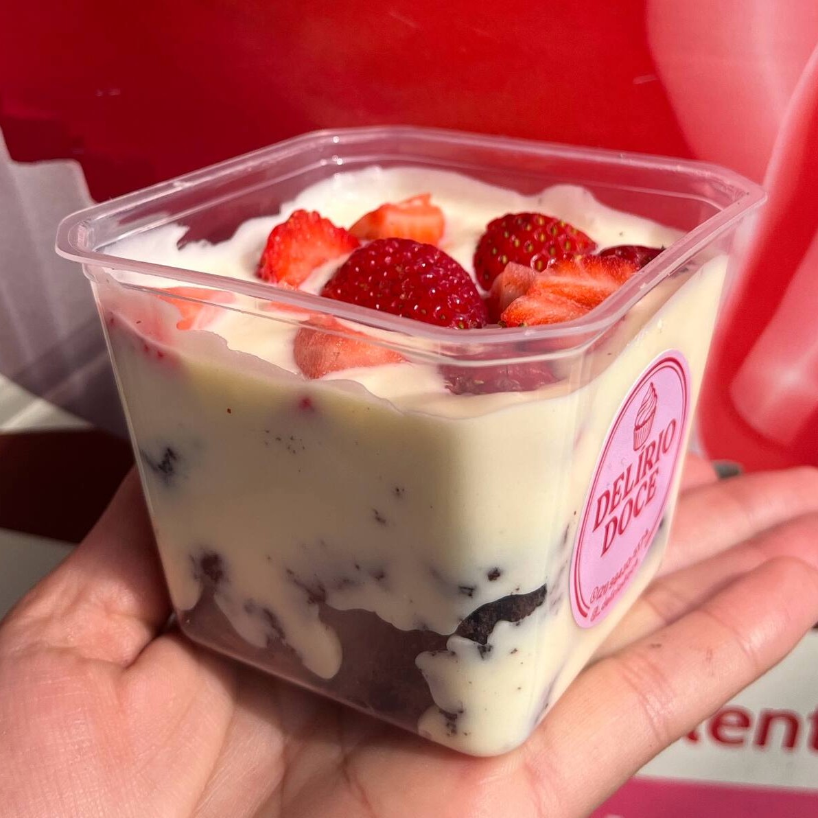 Brownies cortados com creme de Ninho e morangos frescos por cima.