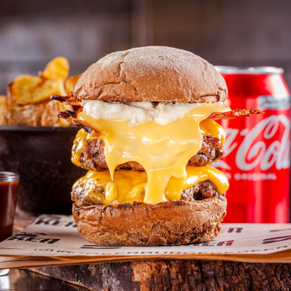 Dois Blends de 150g, cheddar ou prato, bacon em tiras, creme de cheddar, maionese de bacon, no pão australiano.