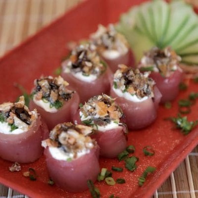 Lâmina de atum fresco batidinho na faca, arroz japonês, cream cheese, cebolinha e gergelim. Sushi