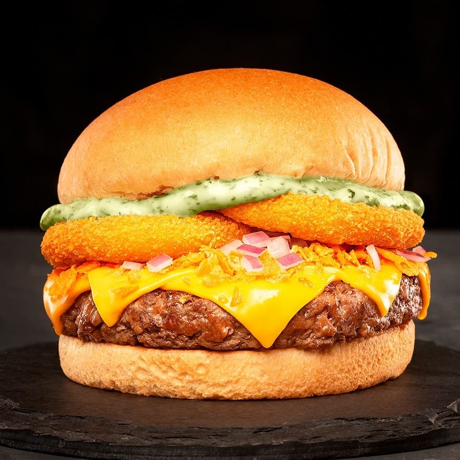 Pão, Blend de 160g, Queijo Cheddar, Maionese de ervas, Cebola roxa picada, Farofa de Doritos e Onion rings.