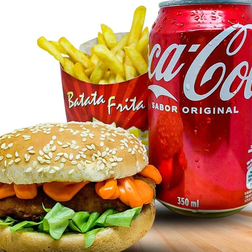 Saboreie nosso inigualável 'Combo Chicken Burger com Coca-Cola'. Este apetitoso combo é formado por um suculento empanado de frango, generosamente recheado com presunto e  queijo derretido. É habilidosamente montado em um pão fresquíssimo e macio, incrementado com alface crocante e uma generosa porção de cheddar cremoso. Acompanha uma porção de batatas fritas crocantes, perfeitamente douradas e uma lata de Coca-Cola, extremamente gelada para revitalizar seu paladar. Um conjunto irresistível, ideal para qualquer momento do Dia.