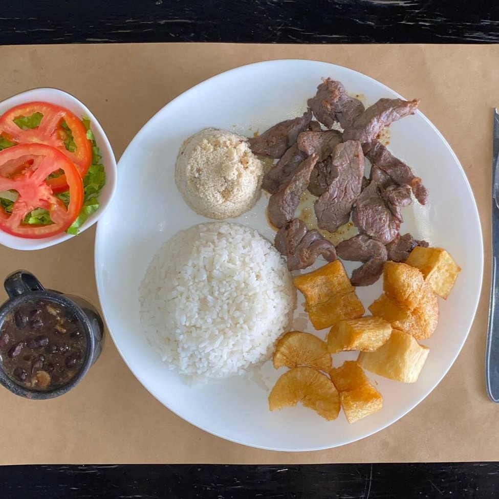 Marmita executiva acompanha: arroz branco, feijão preto, farofa, batata frita e salada de alface com tomate e cebola.