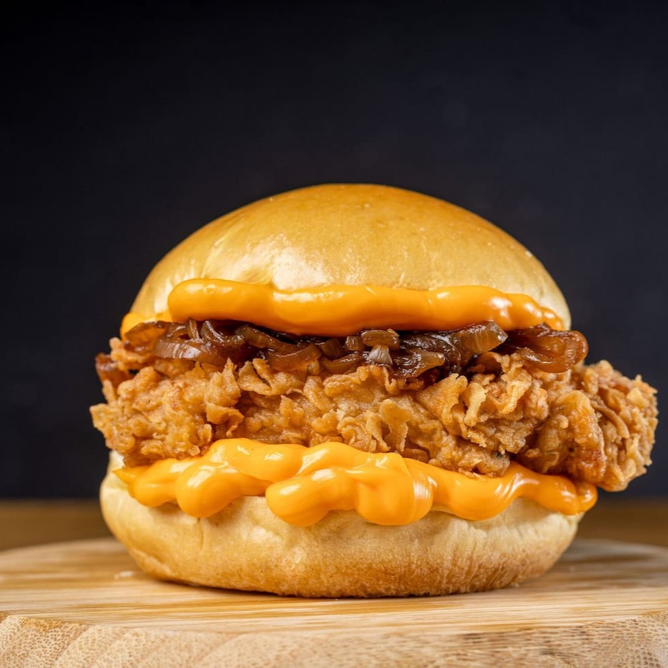 Pão brioche, 2 filezinhos crispy, molho cheddar cremoso e cebola caramelizada douradinha. Crocante, cremoso e levemente adocicado. Um sanduíche que vicia.