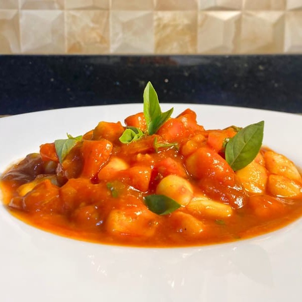 Um prato leve e saboroso, repleto de frescor e ingredientes naturais.  Nhoque artesanal de batata, macio e delicado, combinado com um molho vibrante, feito com manjericão fresco e azeite de oliva. Uma experiência 100% vegana, rica em sabores da horta, que vai conquistar até os paladares mais exigentes. Embalagem especial e bem lacrada. Serve até 1 pessoa.