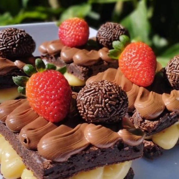 Brownie com recheio leite Ninho com cobertura de chocolate e enfeite de morango com brigadeiro