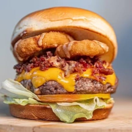 150g de fraldinha, queijo cheddar, anel de cebola, bacon, alface americana, tomate e molho defumado.