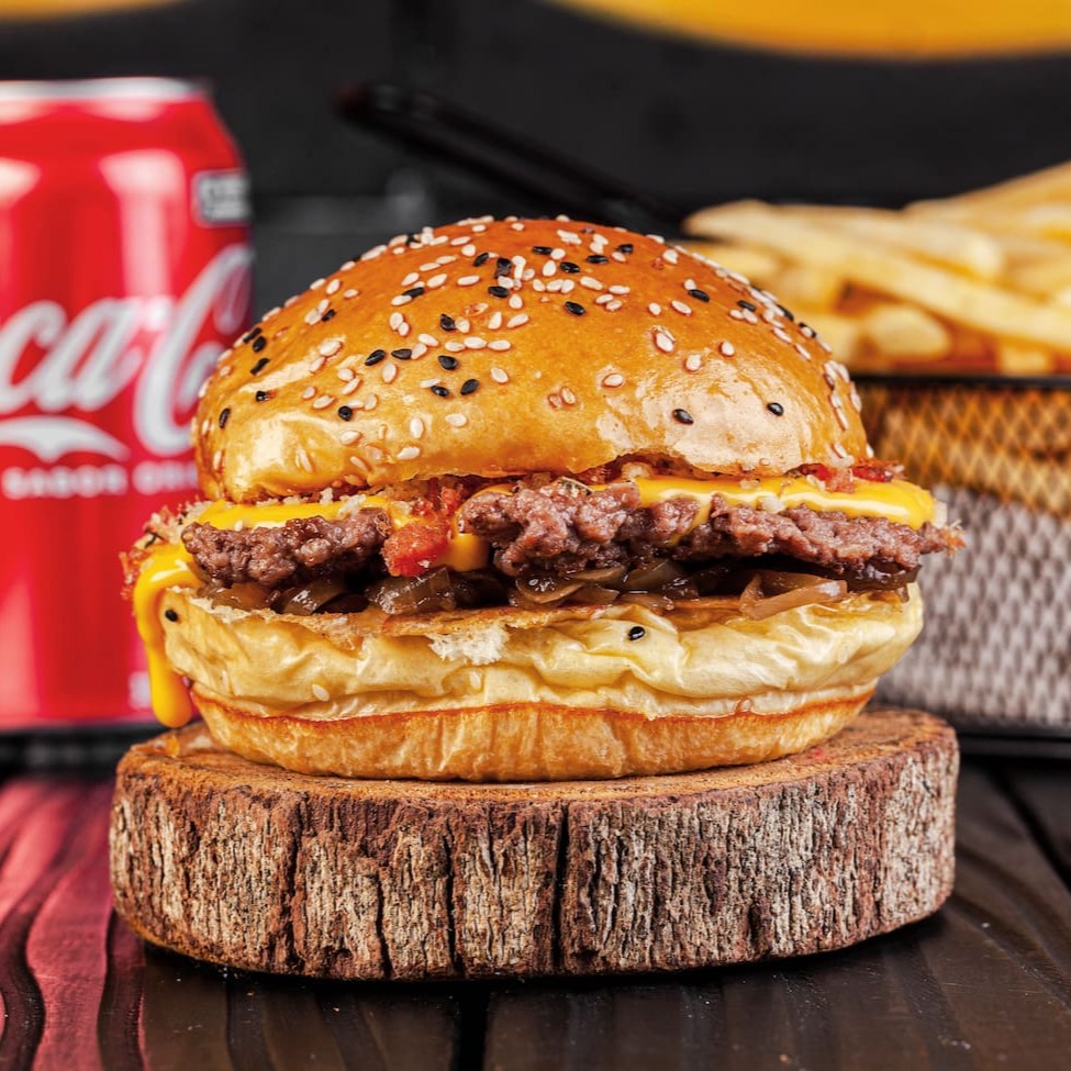 Carne smash 100g, creme de cheddar, farofa de bacon e cebola caramelizada.