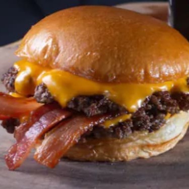 Pão Brioche, 2 carnes smash 100g, fatia de queijo Cheddar Polenghi, Bacon em cubos e Molho Fire