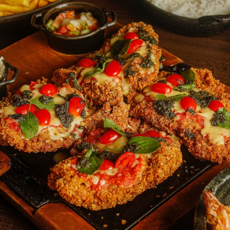 Deliciosos Files de Coração da alcatra a milanesa, finalizados com nosso molho pesto da casa, molho de tomate artesanal, mussarela, tomatinhos italiano e manjericao, acompanham fritas, arroz, vinagrete e farofa! Serve 3 pessoas.